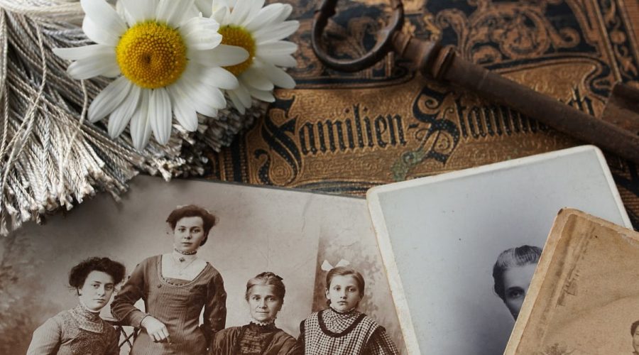 Vintage family photographs with daisies and an antique key evoke memories and nostalgia.
